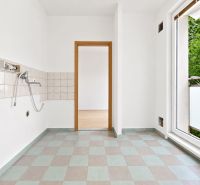 Küche in einer 2-Zimmer-Wohnung mit Fliesen und Balkontür.