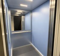 Blaue Aufzugskabine mit Beleuchtung und Spiegel an der Rückwand.