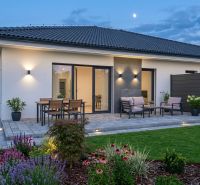 Ein Einfamilienhaus in Hôrka nad Váhom mit Terrasse, Beleuchtung und Garten am Abend.