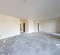 Ein leerer Raum in einem Einfamilienhaus mit Betonboden und weißen Wänden.