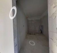 Innenraum eines Einfamilienhauses mit verputzten Wänden und eingebauten Öffnungen für Installationen.