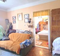 Ein Zimmer in einem Einfamilienhaus mit einem Sofa, Dekorationen und Holzboden.