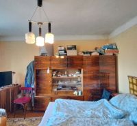 Ein Zimmer in einem Einfamilienhaus mit Möbeln, einem Bett und einem Fernseher, einfaches Interieur.