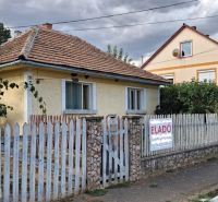 Ein Einfamilienhaus in Tornyosnémeti mit einem Ziegeldach und einem bunten Zaun.