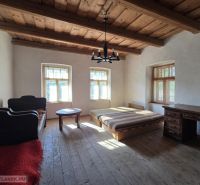Schlafzimmer in einem Einfamilienhaus mit Holzdecke und Boden in Holzoptik.