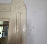 Das Innere eines Einfamilienhauses mit einem Riss in der Wand neben der Tür.