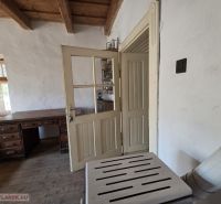 Innenraum eines Einfamilienhauses mit massivem Tisch und rustikaler Holzdecke.