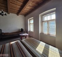 Ein Zimmer in einem Einfamilienhaus mit Holzbalkendecken und natürlichem Licht.