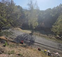 Das friedliche Äußere eines Einfamilienhauses in Hejce mit gepflegtem Garten und befestigter Straße.