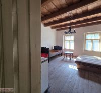 Ein Zimmer in einem Einfamilienhaus mit einer Holzdecke und einfacher Einrichtung.