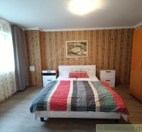 Schlafzimmer im Einfamilienhaus mit Holzboden und gestreifter Bettwäsche.