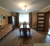 Esszimmer in einem Einfamilienhaus mit Tapeten und Boden in Holzoptik.