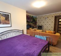 Schlafzimmer in einem Einfamilienhaus mit violetter Decke, Sofa und Kamin.