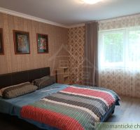 Schlafzimmer in einem Einfamilienhaus mit Doppelbett, Fenster und dekorativen Tapeten.