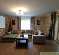 Wohnzimmer in einem Einfamilienhaus mit Sofa, Holzboden und Projektor.