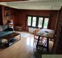 Wohnzimmer in einer Hütte mit Holzboden und Essecke.