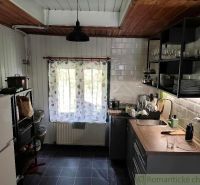 Eine Küche in einer Hütte mit ländlicher Atmosphäre und Holzdekor an der Decke.