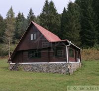 Eine Hütte in Rajecká Lesná, umgeben von Wald, mit einem Steinfundament und einem Dach.