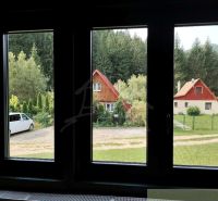 Blick auf die Hütten in Rajecká Lesná, umgeben von Grün und Autos.