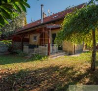 Einfamilienhaus in Bernolákovo, umgeben von einem Garten mit überdachter Terrasse und Ziegelfassade.