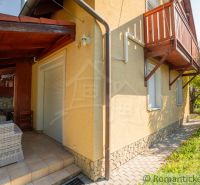 Ein Einfamilienhaus in Bernolákovo mit Garten, Terrasse und Holzbalkon.