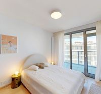 Helles Schlafzimmer in einer 2-Zimmer-Wohnung mit Balkon und Holzboden.