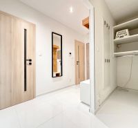 Helles Vorzimmer in einer 3-Zimmer-Wohnung mit weißem Boden und Spiegel.