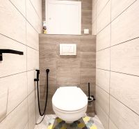 Badezimmer mit Toilette und Holzboden in einer 3-Zimmer-Wohnung.