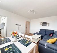Helles Wohnzimmer in einer 3-Zimmer-Wohnung mit Holzboden und bequemer Couch.