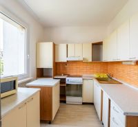 Küche in einer 3-Zimmer-Wohnung, mit orangefarbenen Fliesen und einem Boden in Holzoptik.