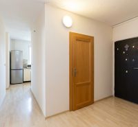 Eingangsbereich in einer 3-Zimmer-Wohnung mit Holzboden und Küche mit Geräten.