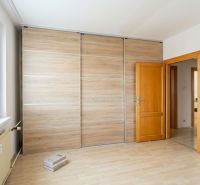 Ein Zimmer in einer 3-Zimmer-Wohnung mit einem Boden in Holzoptik und einem Einbauschrank.