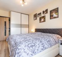 Schlafzimmer mit Einbauschrank, in einer 3-Zimmer-Wohnung; Boden mit Holzdekor.