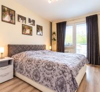 Schlafzimmer mit dekorativem Bett, Nachttisch und Vorhängen in einer 3-Zimmer-Wohnung.