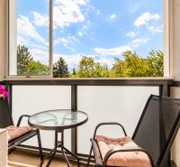 Ein Balkon mit runden Tisch und zwei Stühlen in einer 3-Zimmer-Wohnung.