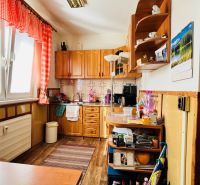 Küche in einer 3-Zimmer-Wohnung, mit Holzboden, roten Vorhängen und Ausstattung.