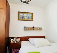 Schlafzimmer in einer 3-Zimmer-Wohnung mit einem Bild und einem Wandregal über dem Bett.