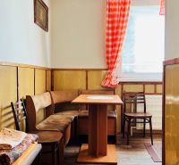 Küchenzeile in einer 3-Zimmer-Wohnung mit Holzdekor und Sitzgelegenheit mit Tisch.