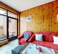 Ein Sitzbereich in einem Einfamilienhaus mit Holzverkleidung und Blick auf den Hof.