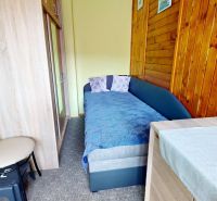 Ein Zimmer in einem Einfamilienhaus mit Holzverkleidung und einfacher Ausstattung.
