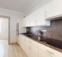 Helle Küche mit Schiebetüren und Holzboden in einem Einfamilienhaus.