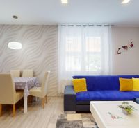 Wohnzimmer in einem Einfamilienhaus mit Holzboden und bunten Accessoires.