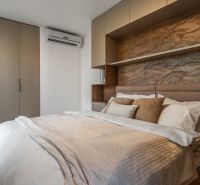 Schlafzimmer mit Doppelbett, Einbauschränken und Boden mit Holzdekor. Wohnungsbau.