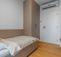 Einzelzimmer mit Bett, Einbauschrank und Boden mit Holzdekor.