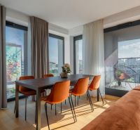 Essbereich mit orangefarbenen Stühlen, Holzboden, Zugang zum Balkon. Wohnungsbau.
