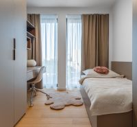 Minimalistisches Zimmer mit Bett, Schreibtisch und Boden in Holzoptik. Wohnungsbau.