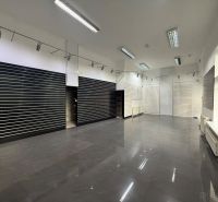 Gewerberäume mit glänzendem Boden, eingebauten Lichtern und Lamellenwänden.