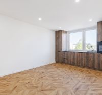 Küche in einer 2-Zimmer-Wohnung mit Holzboden und Einbauschränken.