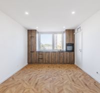 Küche mit Holzboden und eingebauten Geräten in einer 2-Zimmer-Wohnung.
