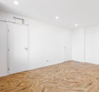 Innenraum einer 2-Zimmer-Wohnung mit Holzboden und eingebauter Küche.